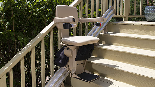 Bruno Elite straight outdoor stairlift in front of bushes