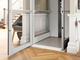 Bruno Connect home elevator's optional power-open door above a wood floor