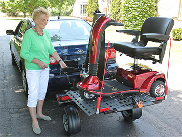 Woman using a Bruno Chariot scooter lift