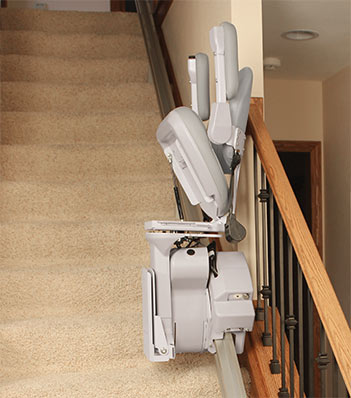 bruno elite stair lift half way up its rail on a staircase