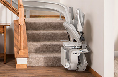 bruno elite curved stair lift stowed and parked at the bottom of a staircase