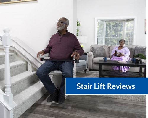 man riding stair lift upstairs with woman in background watching