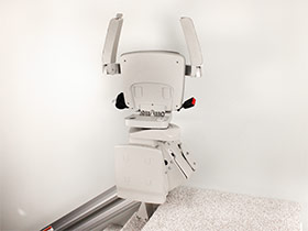 Bruno Elan straight stairlift folded up at top of stairs
