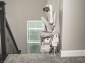 Bruno Elite curved stairlift folded up at top of steps