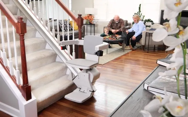 grandparents watching two young kids play in the living room 