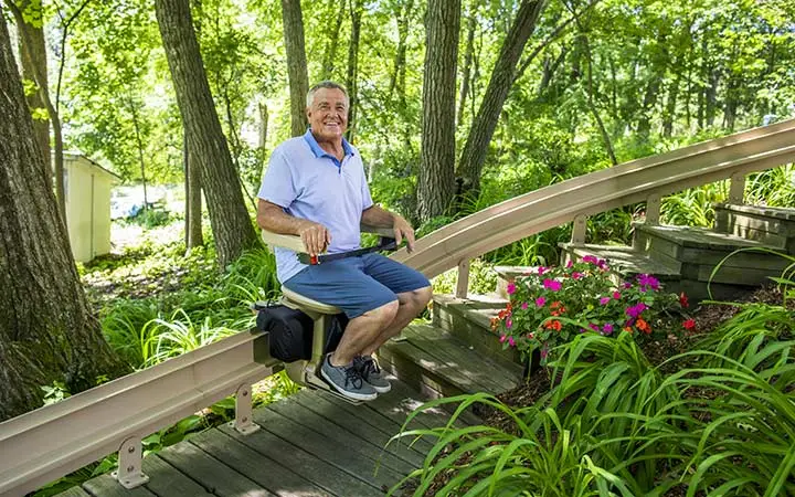 a man riding an outdoor stair lift