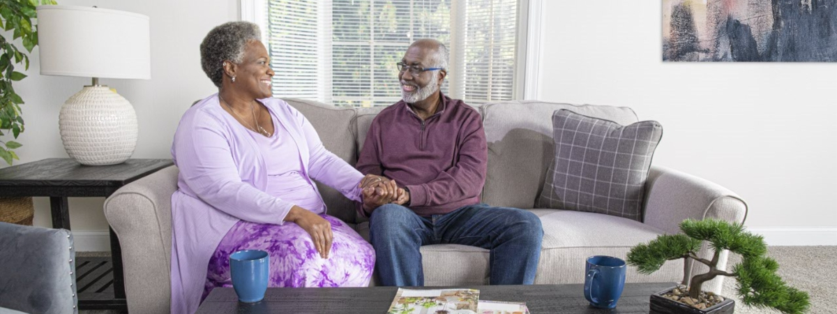 happy couple holding hands while sitting on a couch