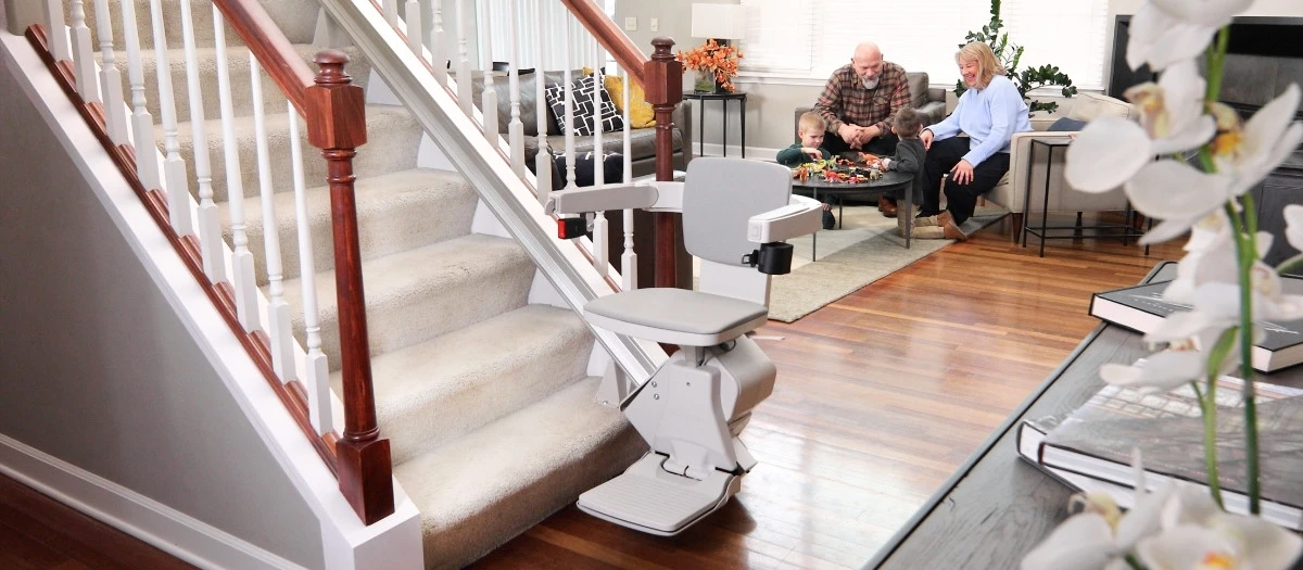 grandparents watching two young kids play in the living room 