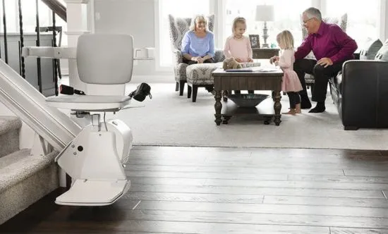 grandparents watching two young kids play in the living room 