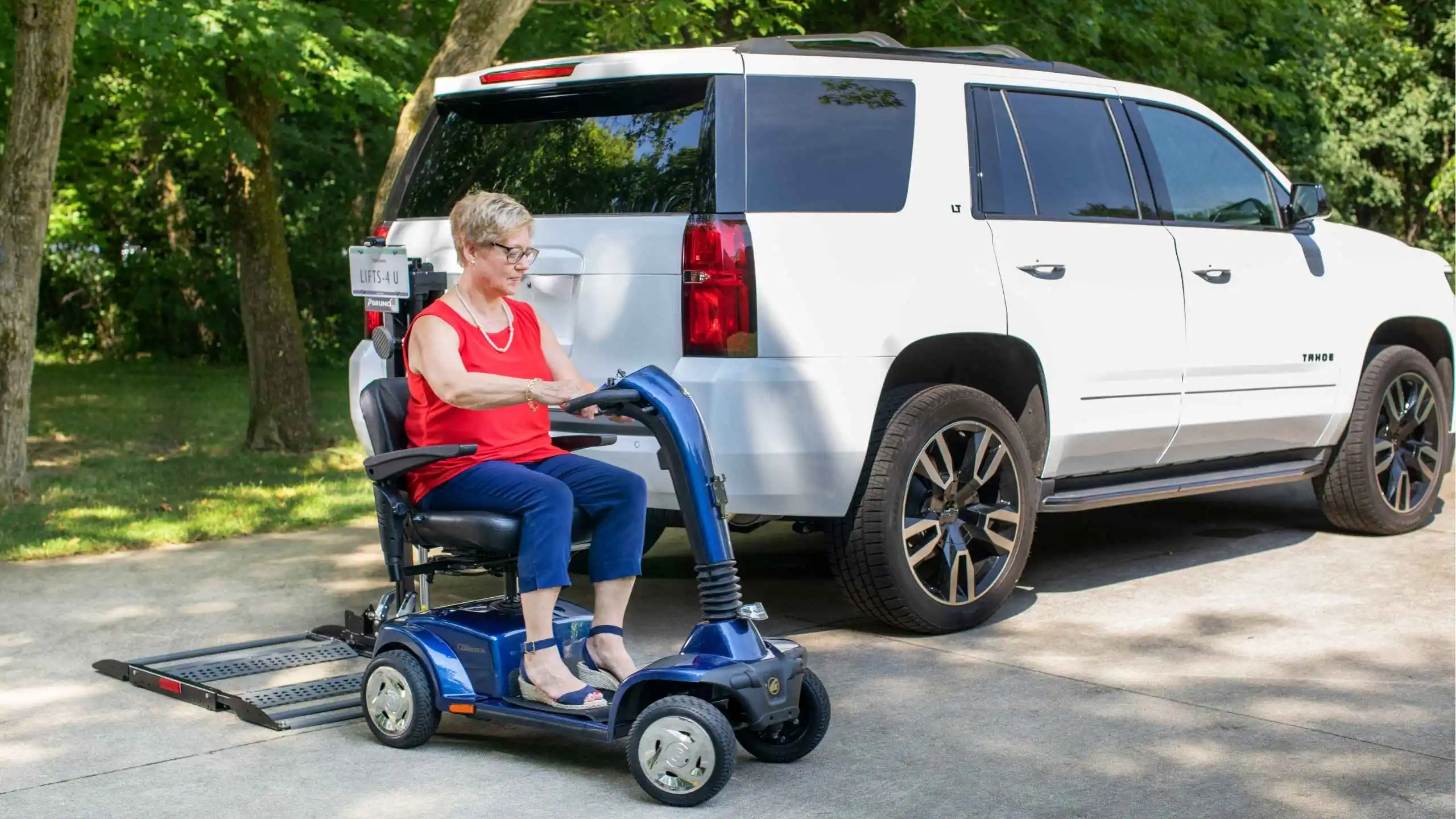a woman on a scooter next to a white suv