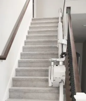  Elan gerader Innentreppenlift, der am Fuß der Treppe zusammengeklappt ist