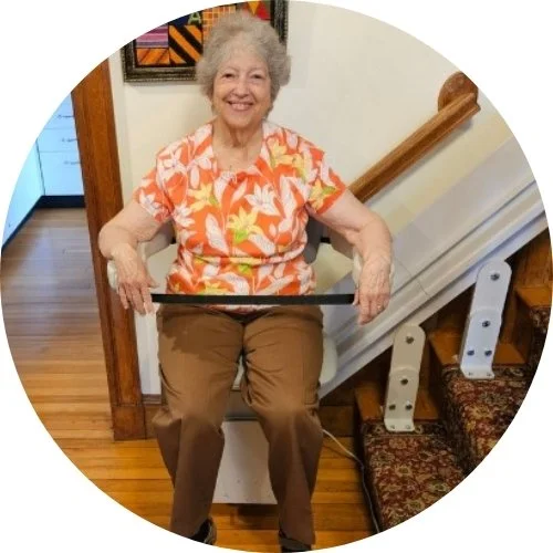 a woman riding an indoor stair lift