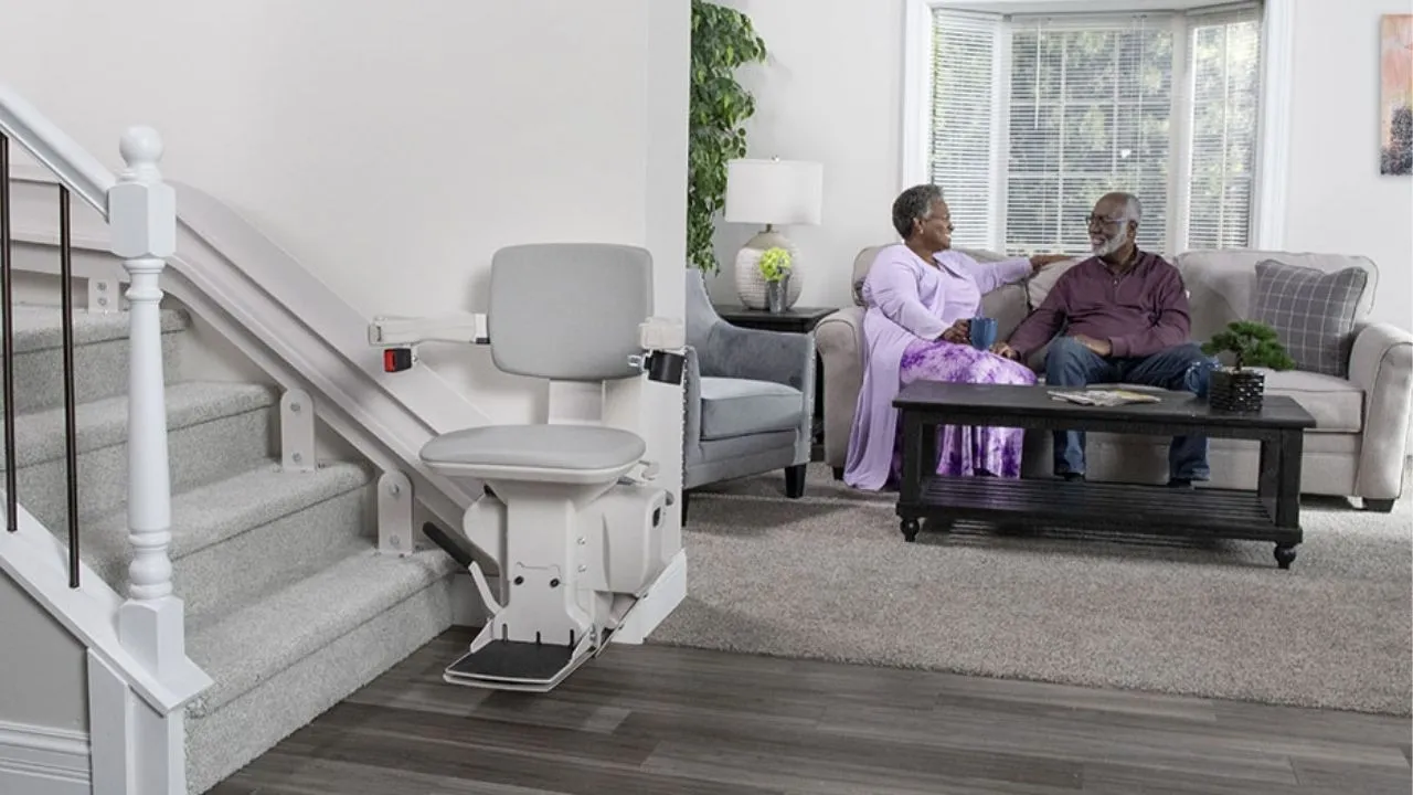 a man and woman sitting on a couch in front of stairs