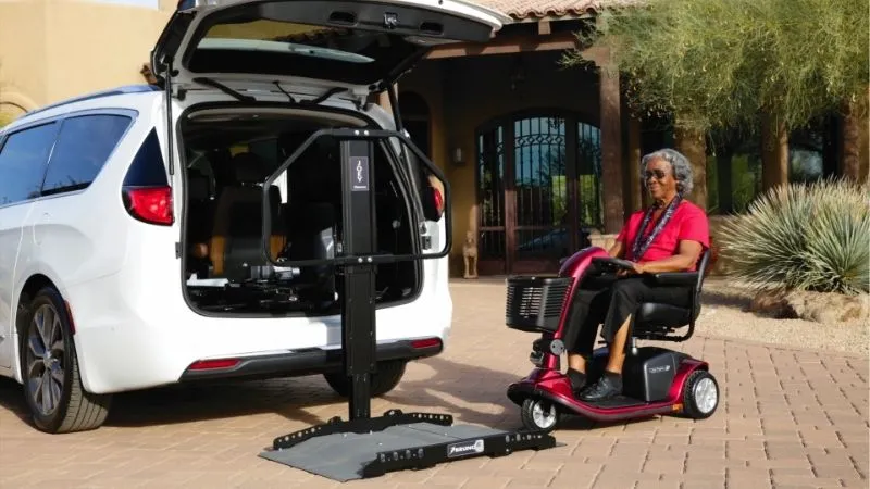 a woman sitting on a scooter next to a car